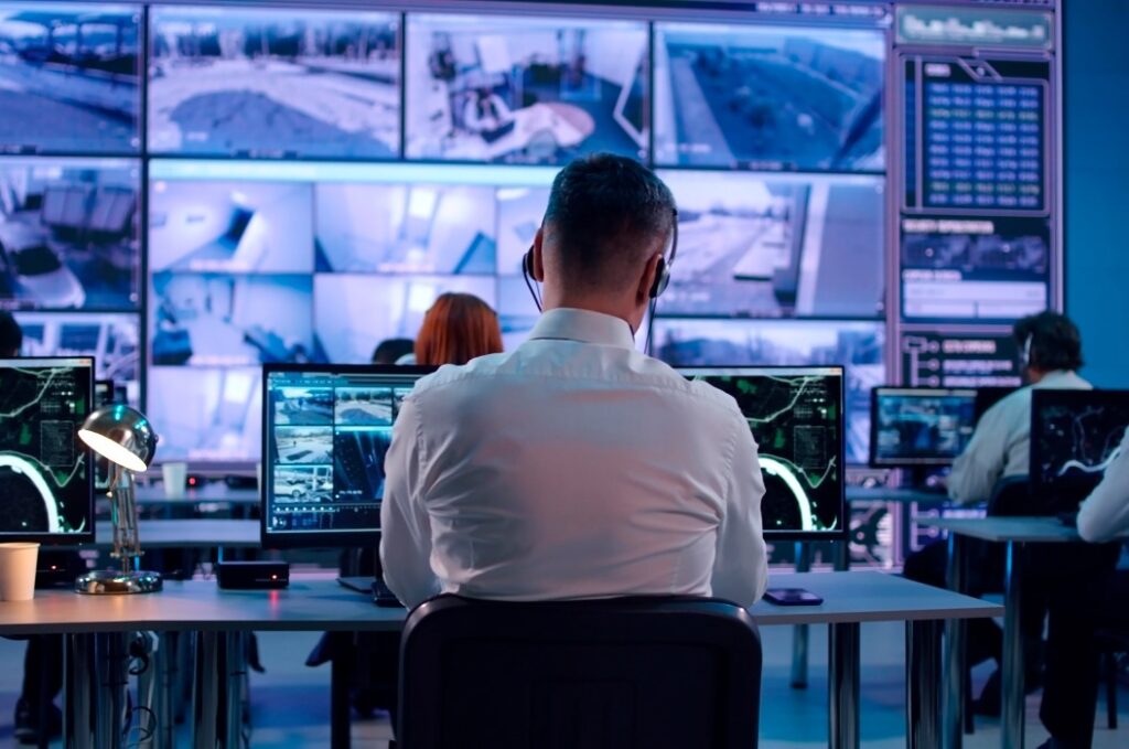 Männlicher Security, der Videos und Karten auf Computern durchsucht